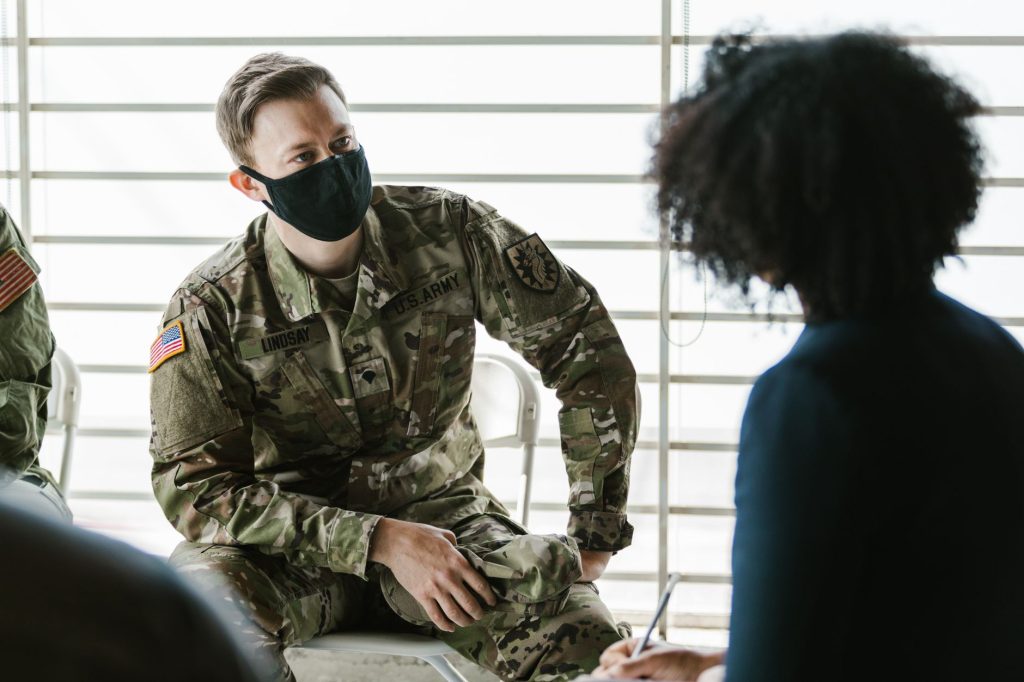 Soldado participa de uma sessão de aconselhamento psicológico em ambiente interno.