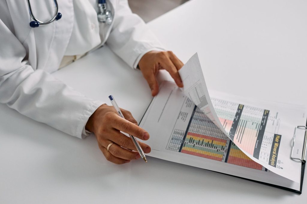 Lei cria avaliação nacional da qualidade de hospitais privados e prevê multas de até R$ 500 mil Profissional de saúde confere relatórios médicos em uma prancheta, em um ambiente hospitalar.