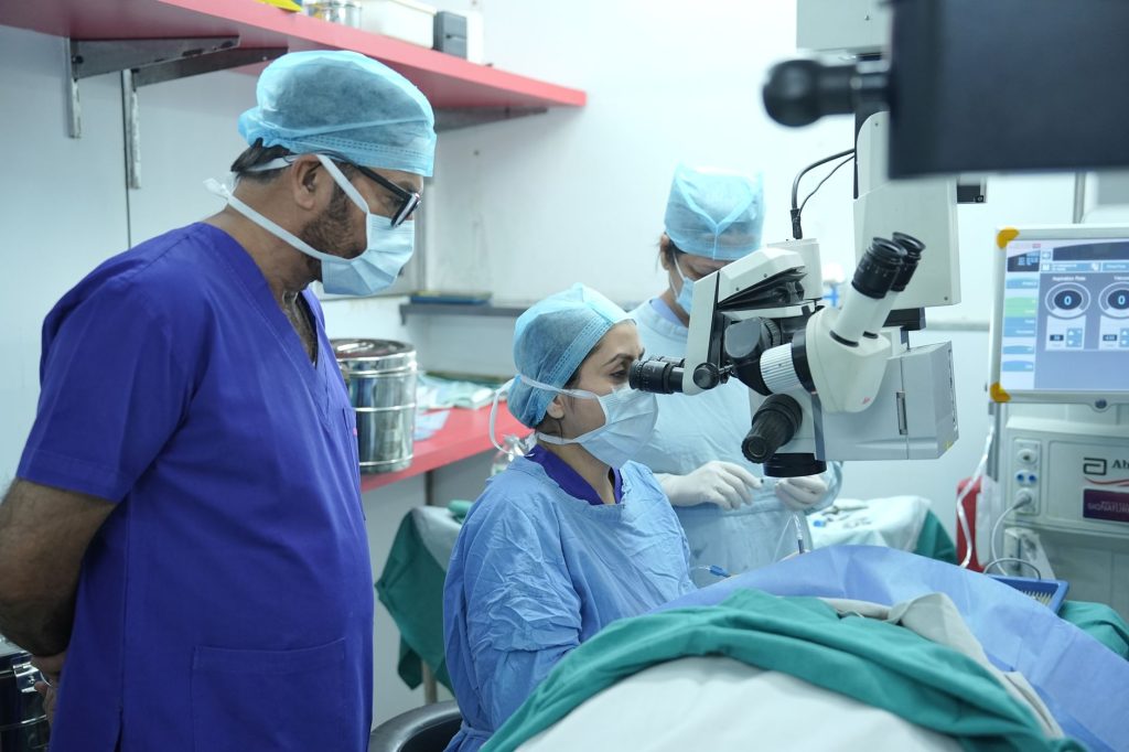 Equipe médica realiza cirurgia oftalmológica em uma sala de operações.