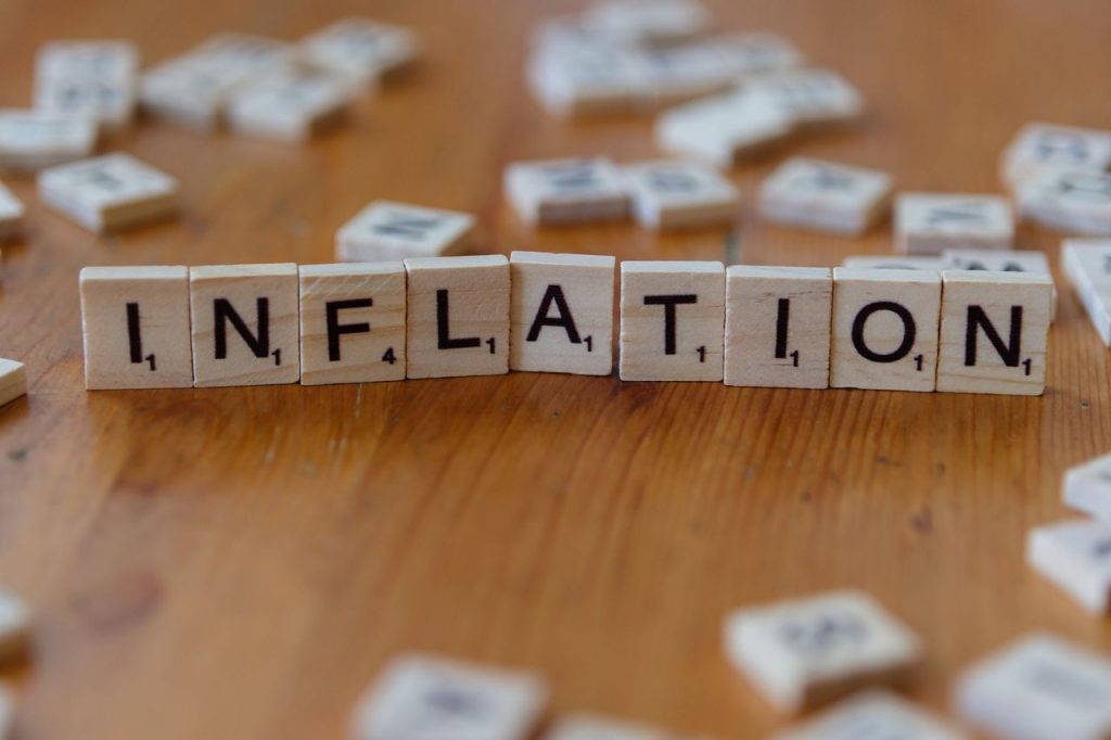 Alta do IGP-10 expõe avanço dos custos antes da chegada ao consumidor Peças de jogo de palavras formando “INFLATION” sobre uma mesa de madeira.